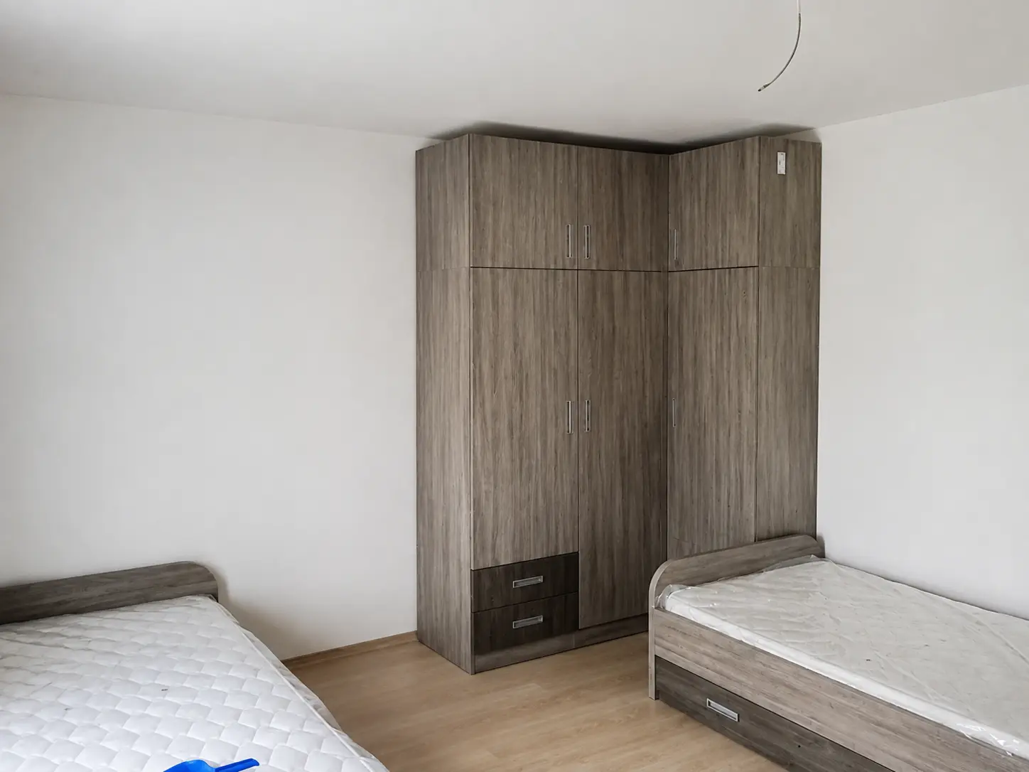 Spavaća soba s dva kreveta i kutnim ormarom po mjeri